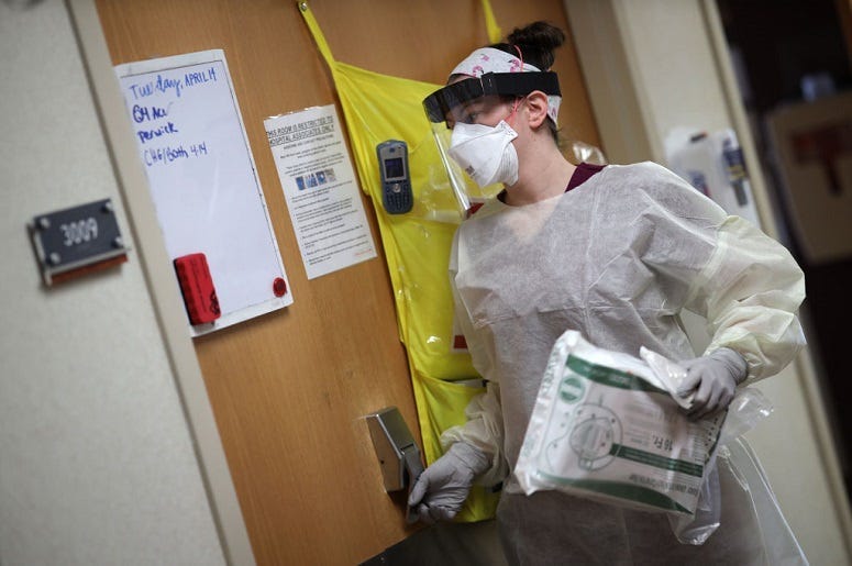 Nurses prepares to enter a COVID-19 patient's room