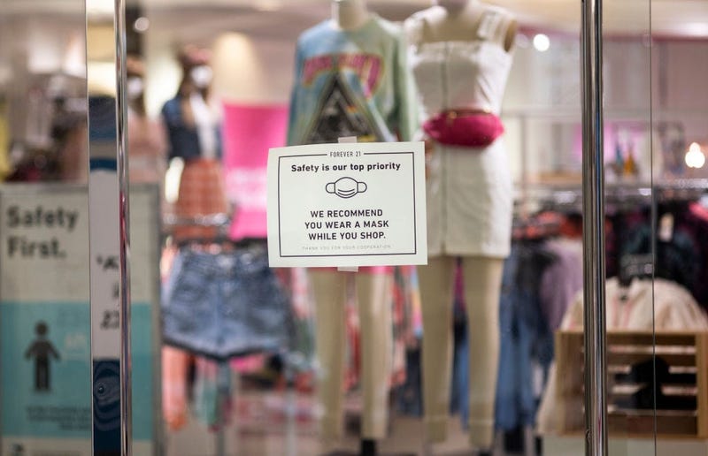 : Signage hung on a window asks customers to wear a mask inside a store at the Mall of America on June 10, 2020 in Minneapolis, Minnesota.