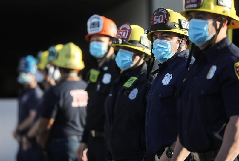 GLENDALE, CALIFORNIA - APRIL 16: Firefighters wear face masks as they stand and pay tribute to healthcare workers during a shift change at Glendale Memorial Hospital amid the coronavirus pandemic on April 16, 2020 in Glendale, California.