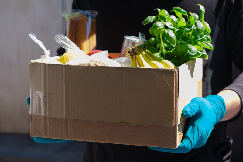 Home delivery during an epidemic. contactless delivery. Food donation. Men's hands hold a box with products
