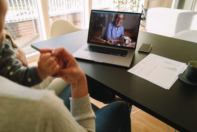Woman with her child having video call with her father. Woman connecting with her father on a video call while at home.