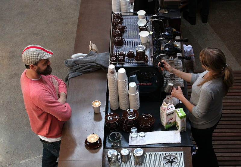 A barista (R) at Sightglass Coffee makes a coffee drink for a customer on August 26, 2011 in San Francisco, California.