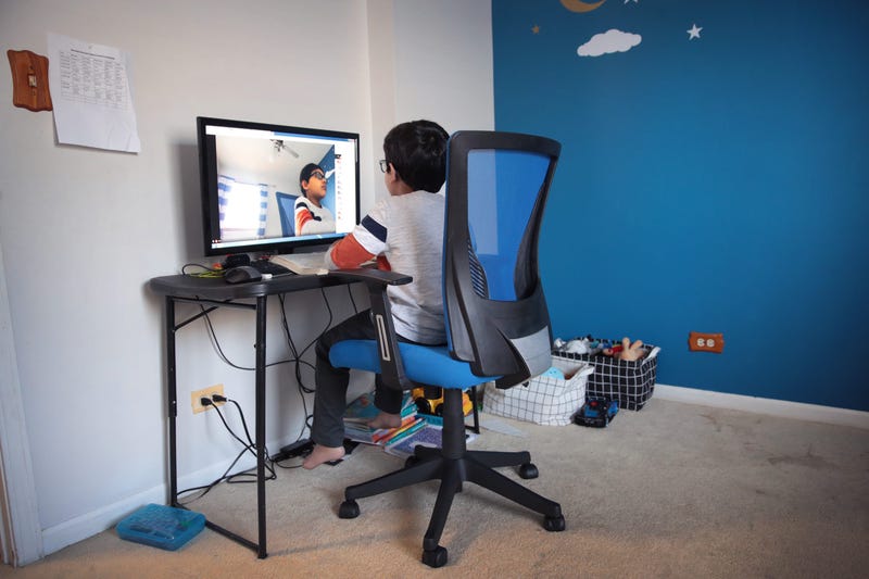 BARTLETT, ILLINOIS - MAY 01: Seven-year-old Hamza Haqqani, a 2nd grade student at Al-Huda Academy, uses a computer to participate in an E-learning class with his teacher and classmates while at his home on May 01, 2020 in Bartlett, Illinois.