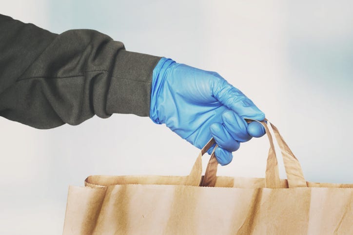 A person giving a bag of food