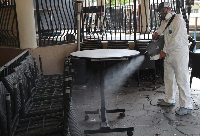 Edwin Britto, from Copax llc.) sprays a decontamination fog as he sanitizes a restaurant before it opens on May 18, 2020 in Fort Lauderdale, Florida.