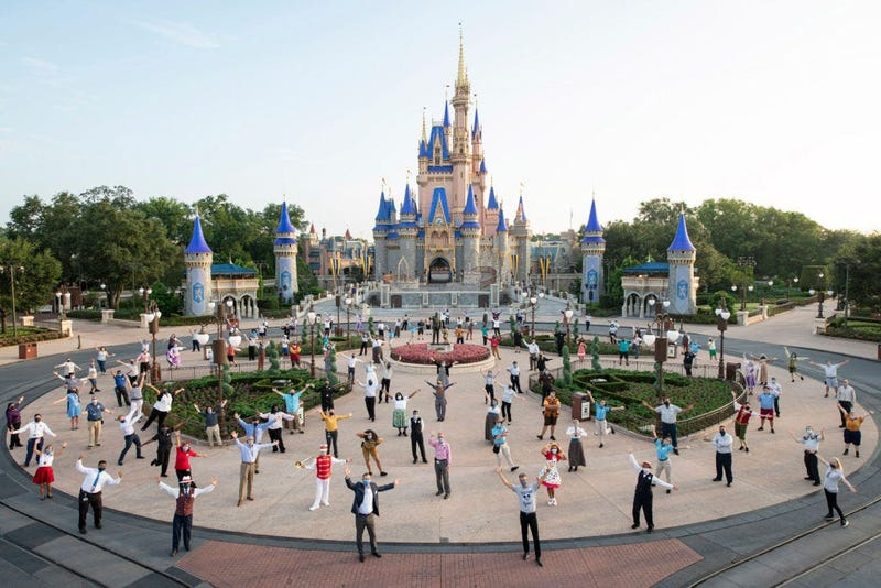 Disney cast members pose for a photo in front of Cinderella Castle prior to the phased reopening of Magic Kingdom Park at Walt Disney World Resort