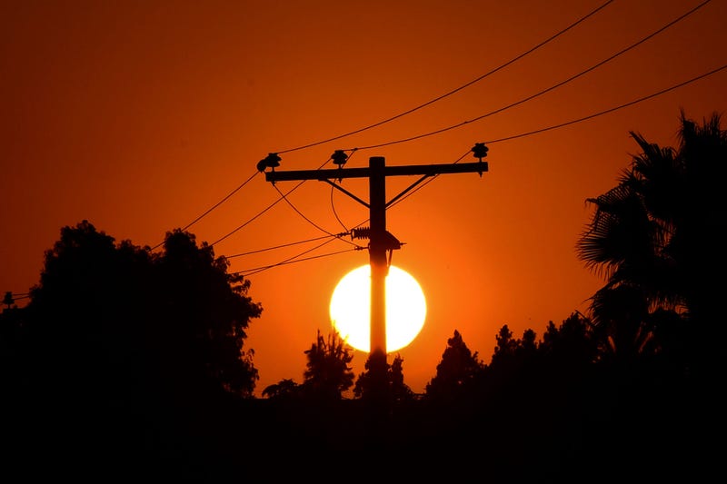 The sun sets behind power lines in Los Angeles, California on September 3, 2020, ahead of a heatwave to arrive September 4 through the Labor Day weekend prompting a statewide flex alert. 