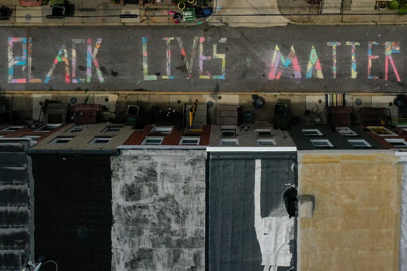 In an aerial image from a drone, a 'Black Lives Matter' mural chalk painting is seen on the 300 block of South Madeira Street on June 16, 2020 in Baltimore, Maryland.