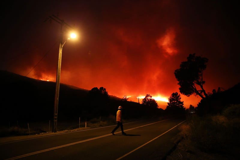 A man walks in protective gear as the Lake Fire burns nearby on August 12, 2020 in Lake Hughes, California.