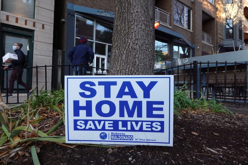 A sign along the sidewalk in an area lined with bars and restaurants in the Wicker Park neighborhood encourages people to stay home on November 11, 2020 in Chicago, Illinois.