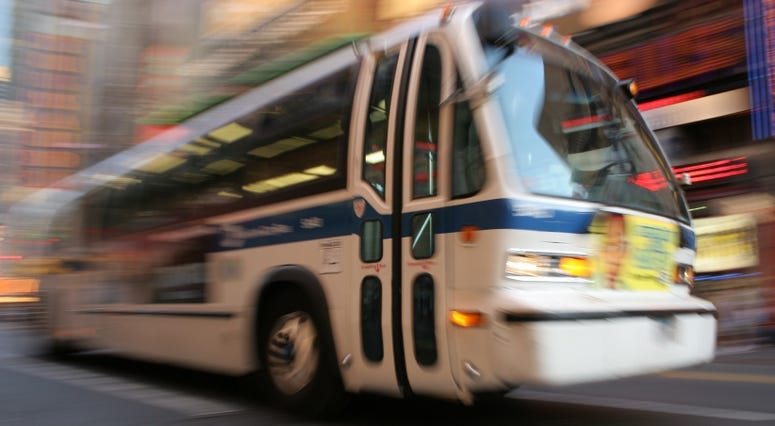 City bus passes by on busy street