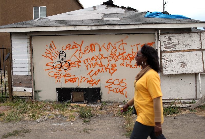 A member of the Richmond, California chapter of the Alliance of Californians for Community Empowerment (ACCE) walks by an abandoned garage during a bus tour of foreclosed and blighted properties on July 13, 2012 in Richmond, California. 