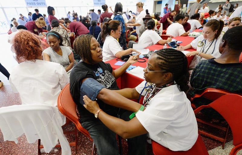 Alice Rainwater (C) get her blood pressure checked by licensed vocational nursing student Alisa Humphrey (R) as part of a free health care service at the Care Harbor clinic at the Los Angeles Sports Arena on September 27, 2012 in Los Angeles.