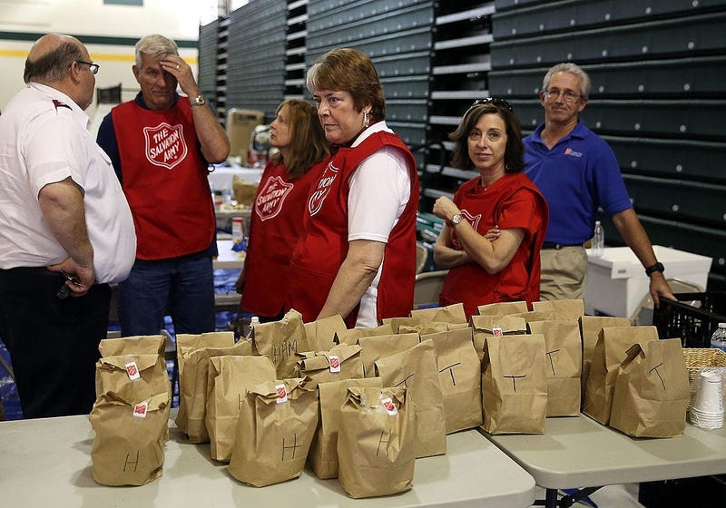 salvation army disaster volunteers behind a table of fod bags