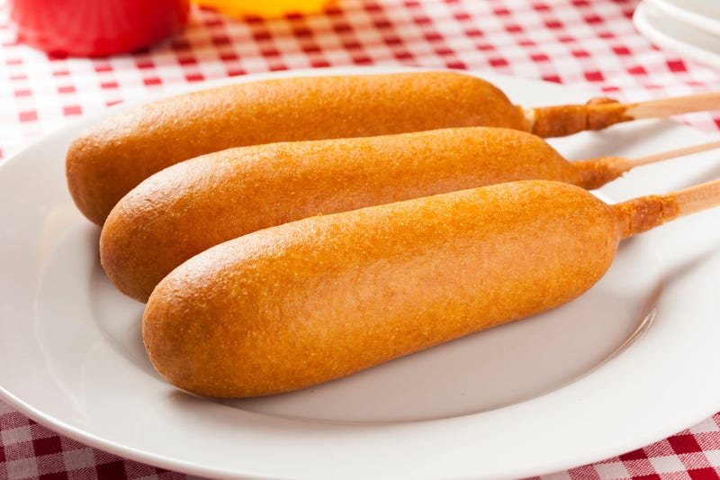 Corn dogs with ketchup and mustard on white background
