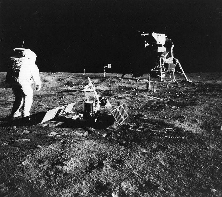 1969: Apollo 11 astronaut Edwin 'Buzz' Aldrin deploys a scientific experiment package on the surface of the moon. In the background is the Lunar Module, as is a flag of the United States.