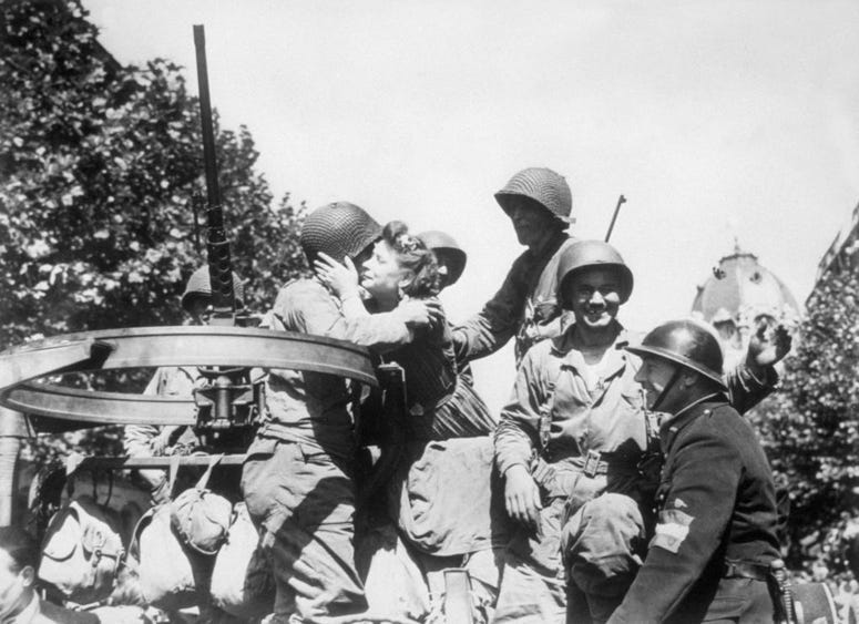 Parisian girls welcome the liberating US troops arriving in Paris.
