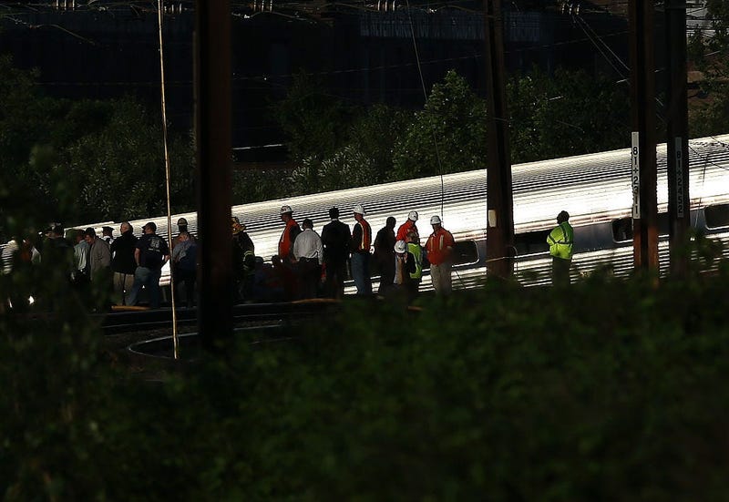 Investigators and first responders work near the wreckage of an Amtrak passenger train carrying more than 200 passengers from Washington, DC.