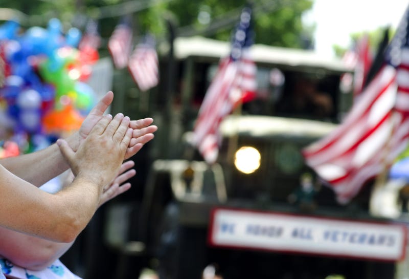 A spectator applauds during a parade honoring U.S. Veterans