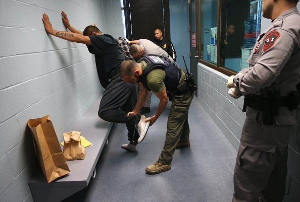 U.S. Immigration and Customs Enforcement (ICE), agents frisk a detained immigrant at a processing center on October 14, 2015 in Camarillo, California. ICE builds deportation cases against thousands of both undocumented and Green Card holding immigrants co