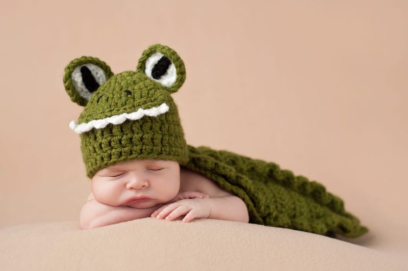 Baby sleeping in alligator crocheted blanket