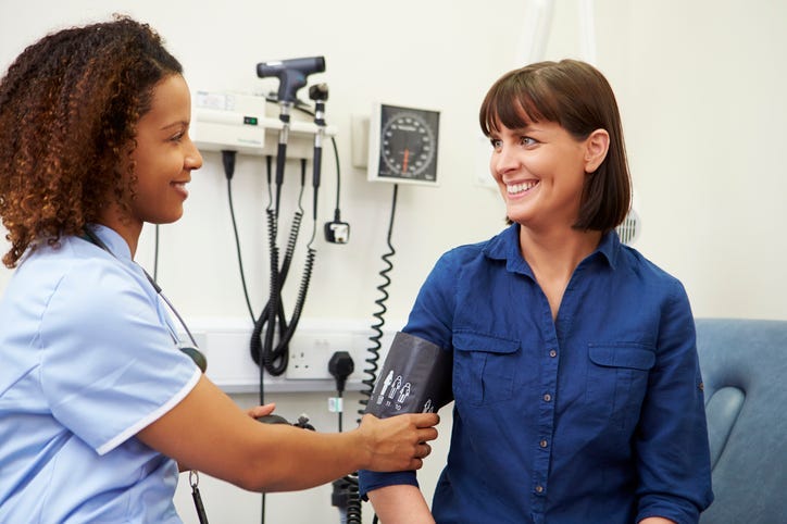 A woman getting her blood pressure checked by a doctor.