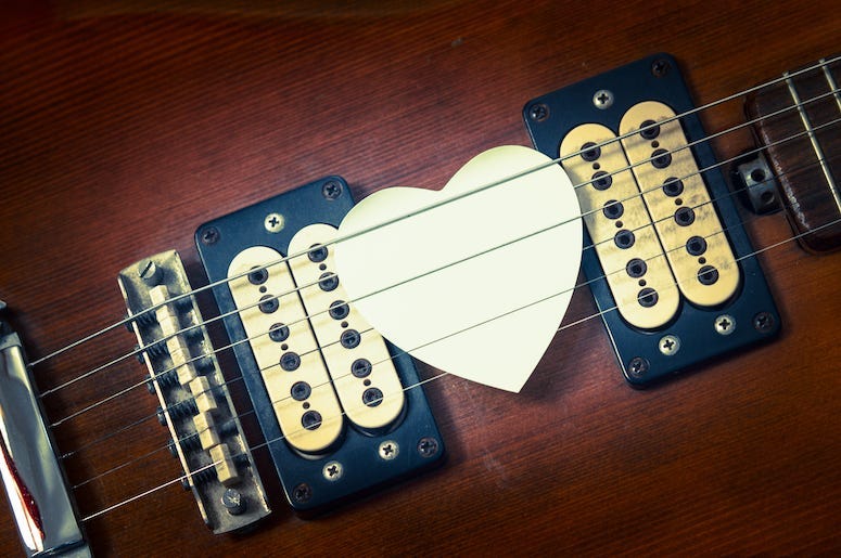 Guitar with a heart shaped pick.