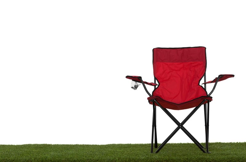 Folding camp chair front view on grass with white background