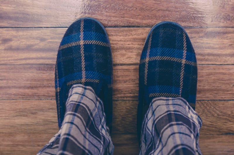 Man wearing pajamas and slippers on hardwood floor