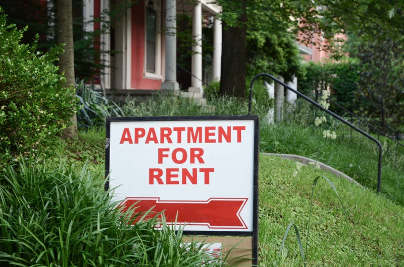 A sign in a front yard reads, "Apartment for Rent"