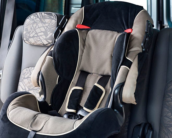 Photograph of a child safety seat in backseat of car.