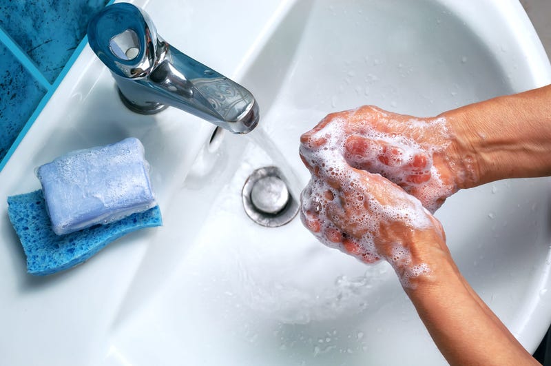 Person washing hands with soap and water in sink