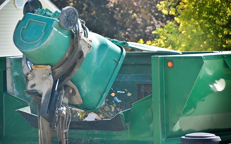 Garbage container being dumped into truck