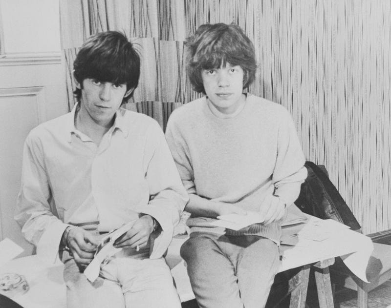 Mick Jagger and guitarist Keith Richards opening fan mail during the early days of the band, circa 1963.
