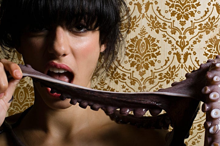 Woman biting an octopus tentacle