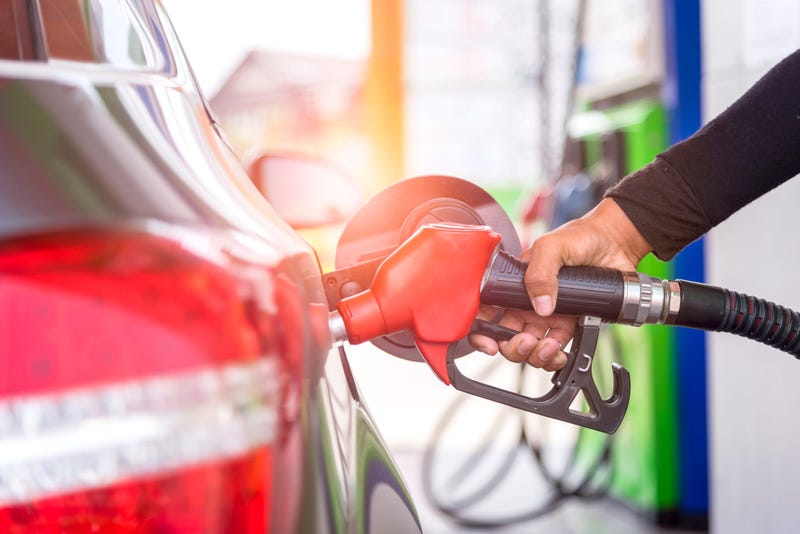 car fuels concept, oil station hand and fuel nozzle in car