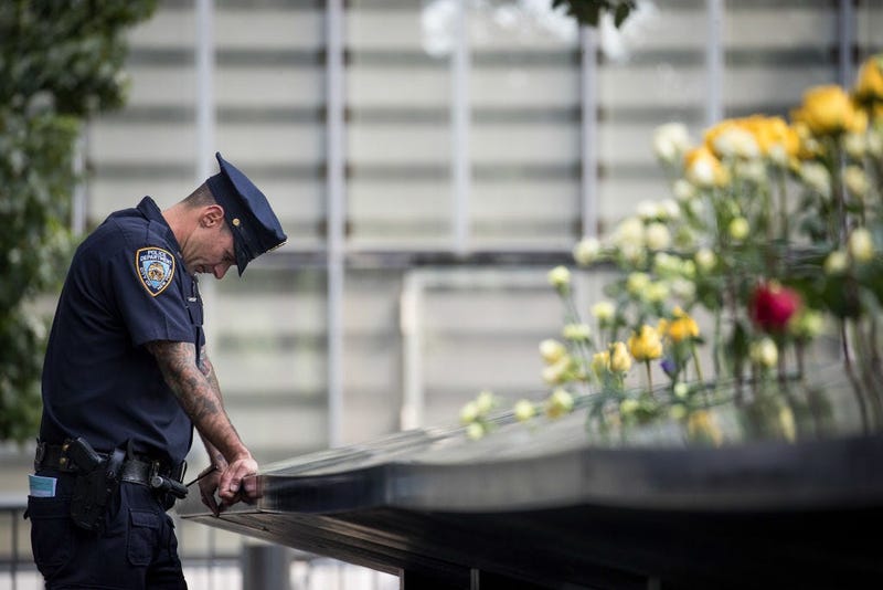 A New York City Police Department (NYPD) officer pauses while visiting the North pool during a commemoration ceremony for the victims of the September 11 terrorist attacks at the National September 11 Memorial,