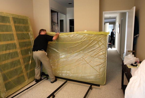 Pestec technician Darrell Azlin moves a bed as he preapares to use a heat treatment at an apartment with bed bug