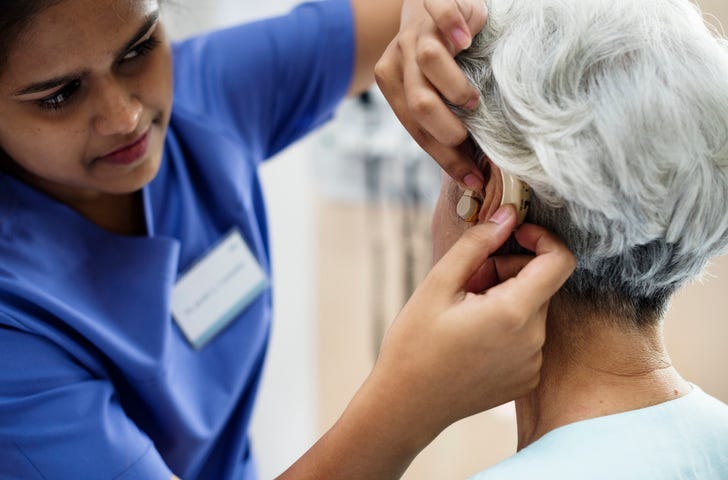 An elderly woman with hearing aid