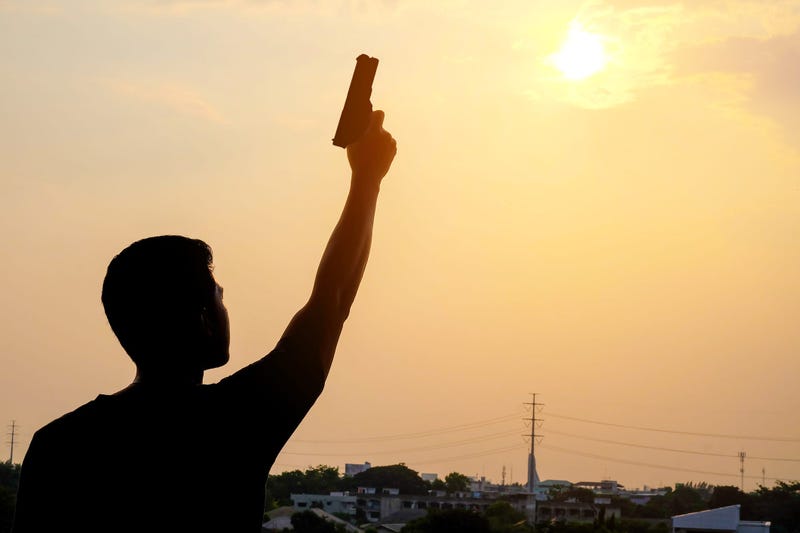 a man lifting a hand holding a gun