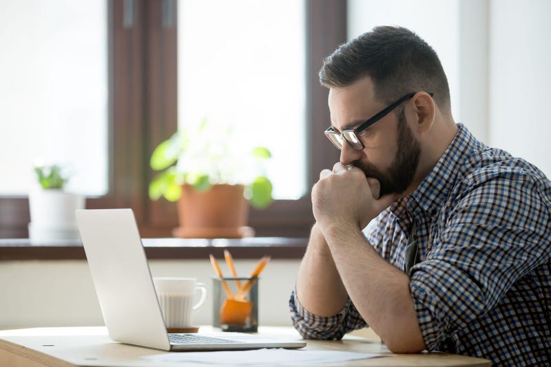 Man looks contemplative about what he sees on computer screen