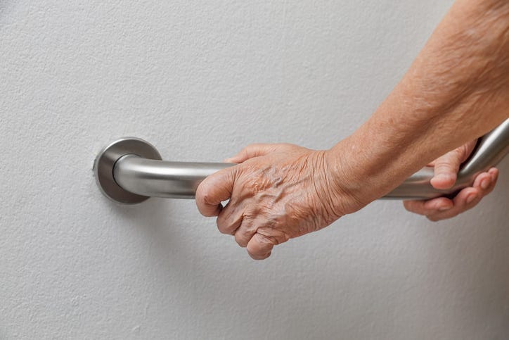 Holding on the railing to prevent falling.
