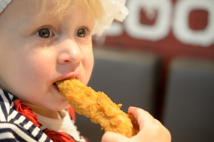 baby eating chicken