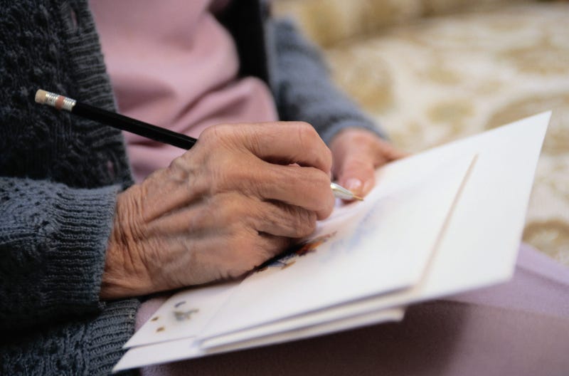 Older woman's hand writing a letter