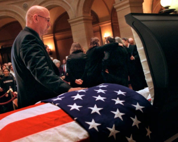 Former Minnesota Governor Harold Stassen lies in state in the State Capitol Rotunda in 2001. Minnesota Governor Jesse Ventura pays his respects to Stassen while standing next to Stassen's flag-draped coffin in the State Capitol Rotunda.