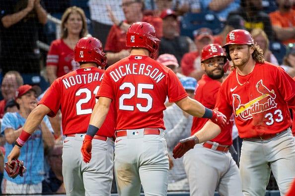 Lars Nootbaar (21), Corey Dickerson (25), and Juan Yepez (center) celebrate with Brendan Donovan (33) during an MLB spring training game against the Washington Nationals.