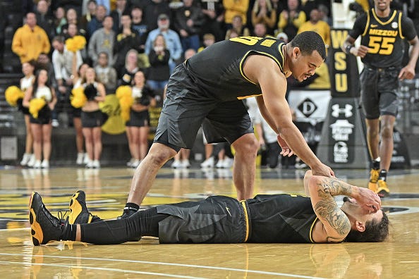 Tre Gomillion #2 of the Missouri Tigers reacts after missing a shot at the end of regulation to send the game into overtime as teammate Nick Honor #10 offers a hand.