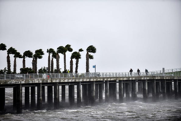 Local residents walk in the middle of the rain and heavy wind at the St. Pete pier as Hurricane Ian hits the west coast on Sept. 28, 2022, in St. Petersburg, Florida. Ian is hitting the area as a likely Category 4 hurricane.