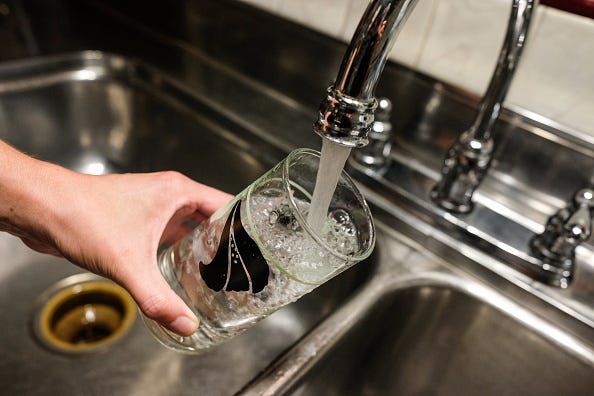 Faucet filling a glass of tap water