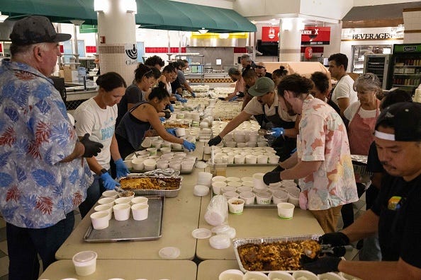 Volunteers prepare free meals to donate to West Maui families affected by wildfires, at the University of Hawaii Maui College in Kahului, Maui